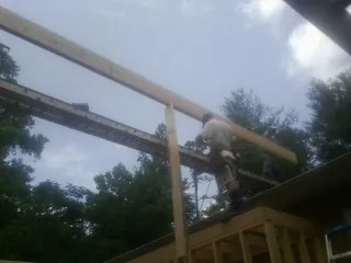 Carpenter setting a ridge beam over a new addition frame — Ice Dam Removal by Roofing Brothers in Old Westbury