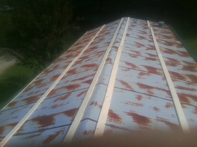 Rusted metal roof panels with new wood purlins before replacement — Storm Damage Roof Repair in Old Westbury by Roofing Brothers