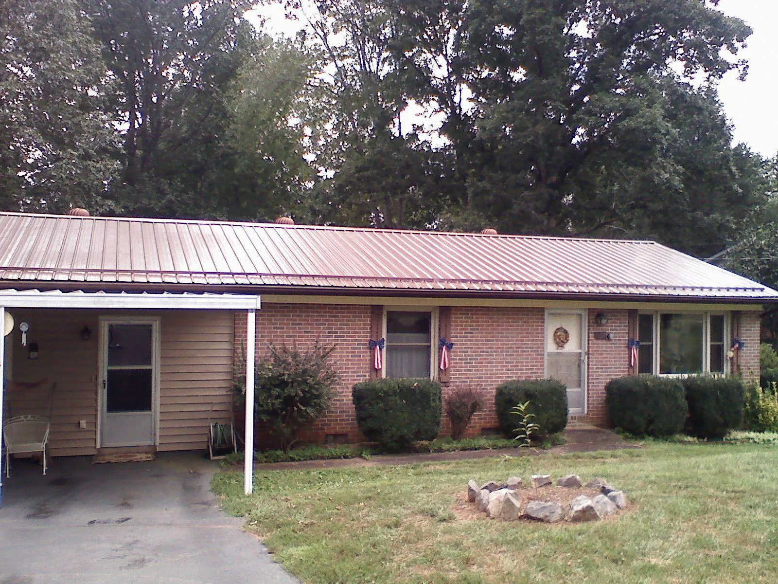 Bronze metal roof and carport on a brick ranch home — Roof Repair work by our crew in Old Westbury